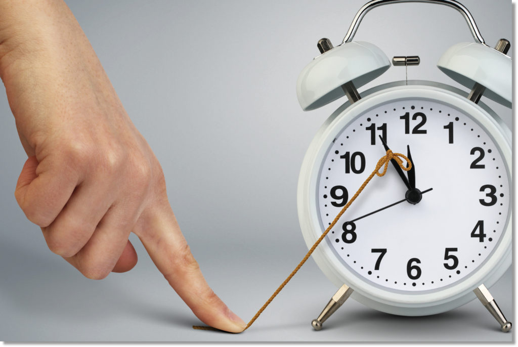 Finger holding a string attached to a clock to prevent time from moving.